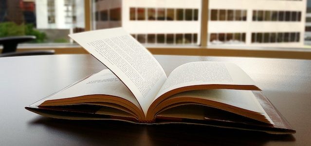 open book with window overlooking an office block